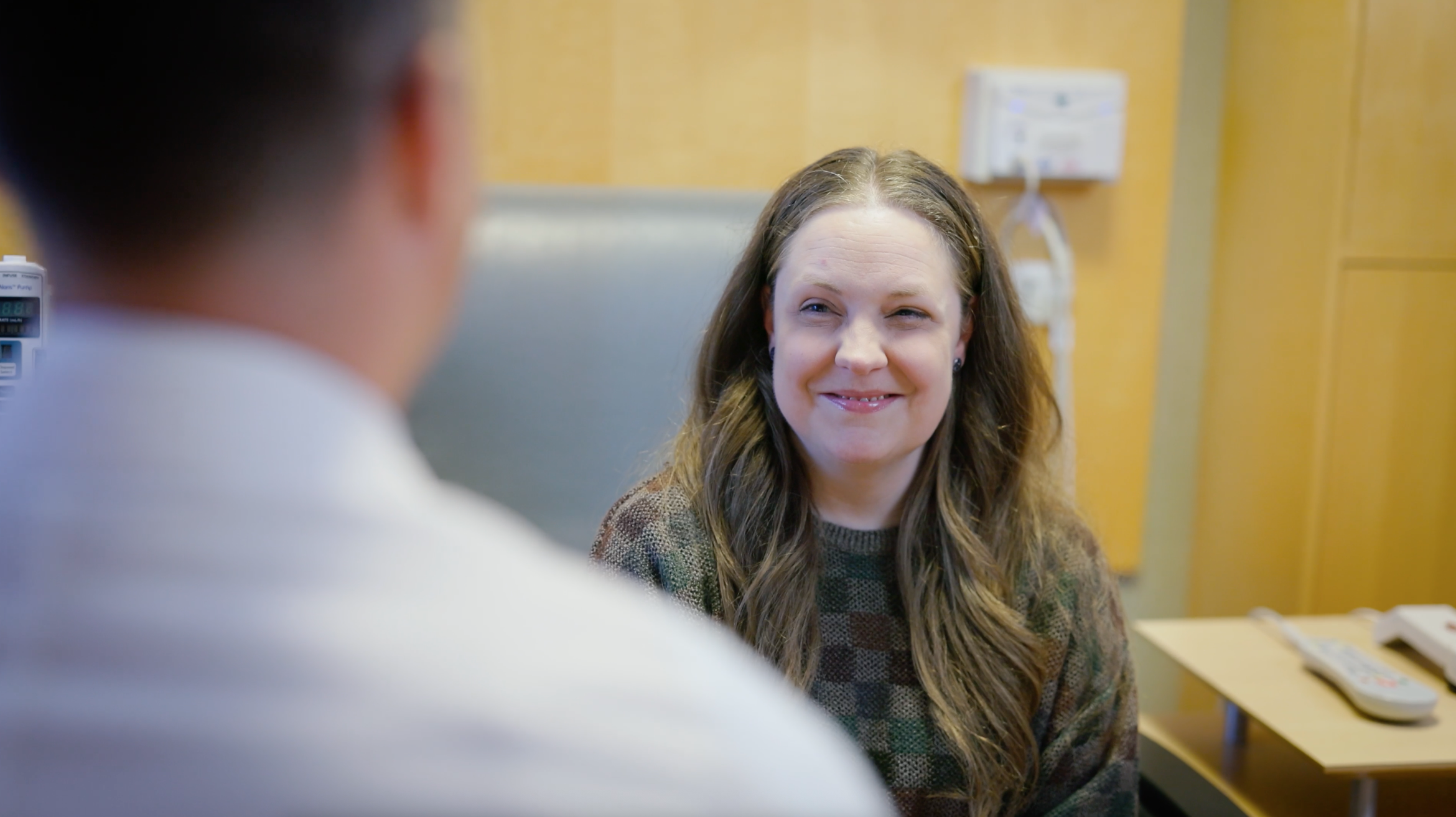 Patient Tracy Riffe smiling in an exam room with Dr. Macari