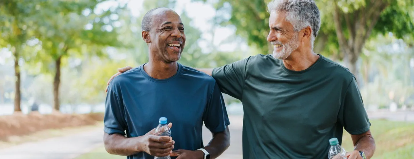 Two mature men walking together after a run. 