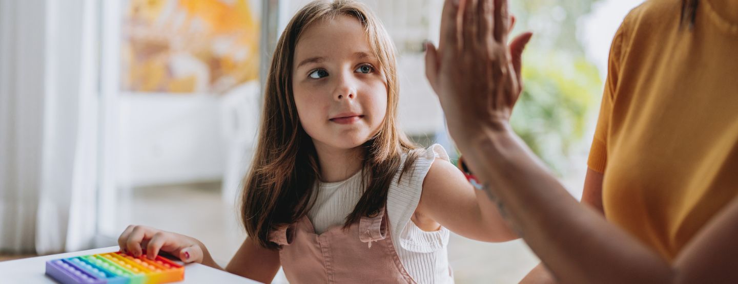 Mother high fives daughter while working on counting activity. 