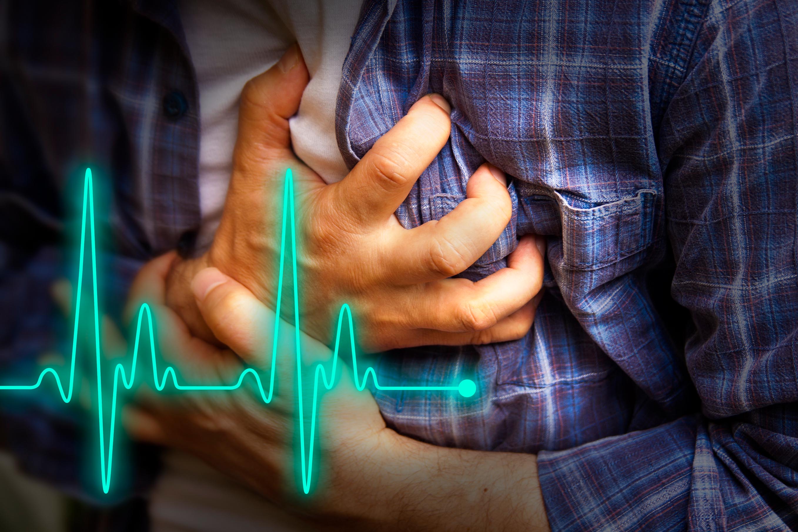 A man in blue shirt is clutching his chest while having a heart attack. A heart beat line goes across the picture.