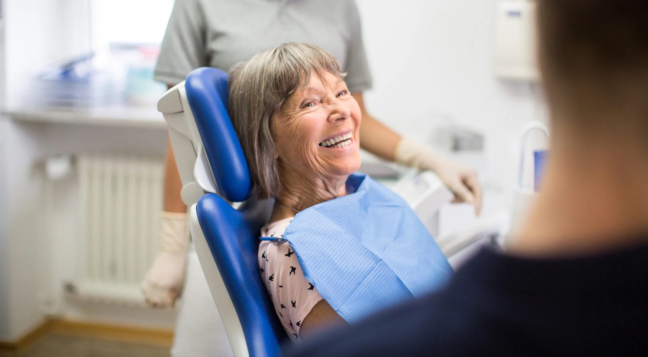 Senior woman smiling and listening to her dentist during consultation