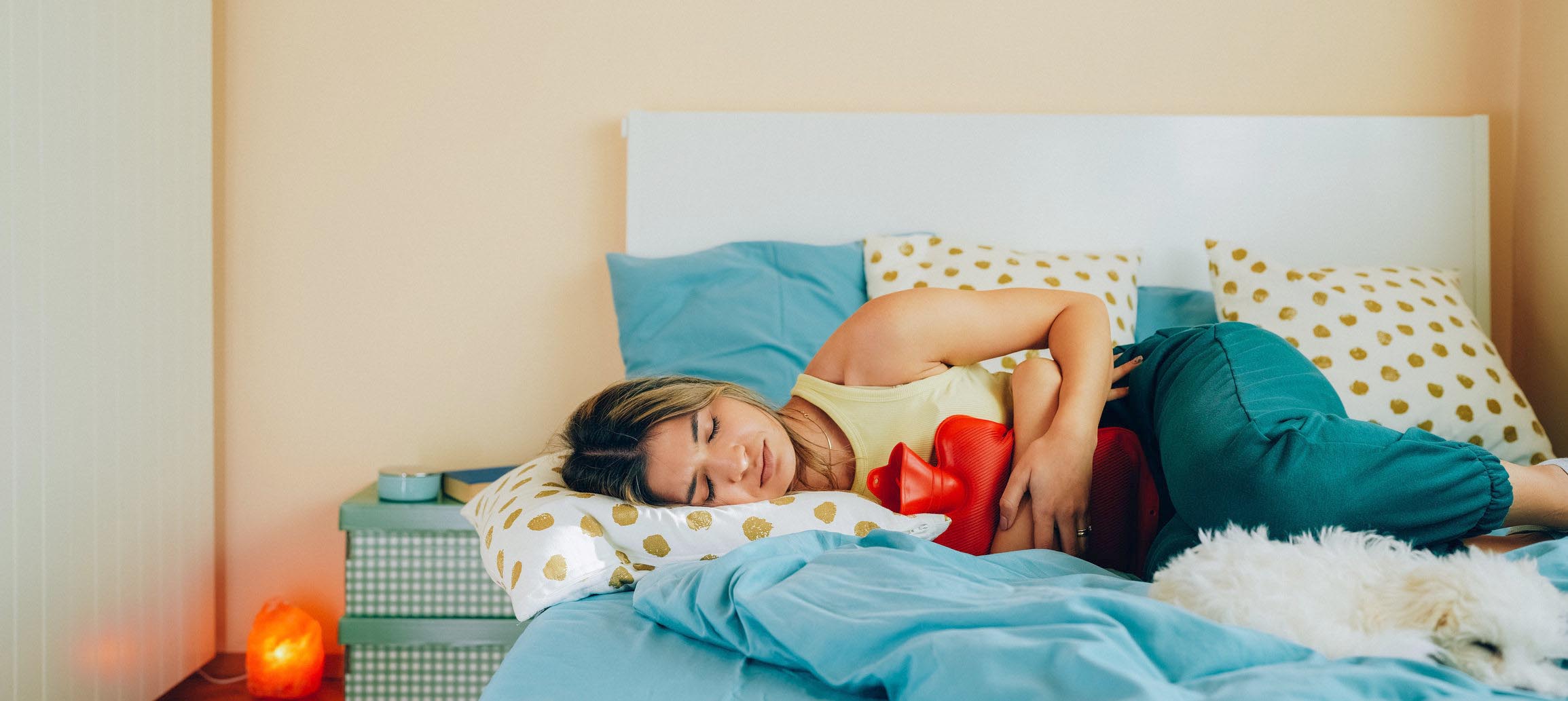 Young woman with painful menstruation resting in bed