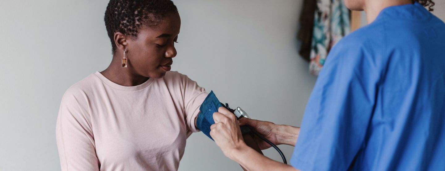Young woman getting blood pressure checked at the doctor's office. 