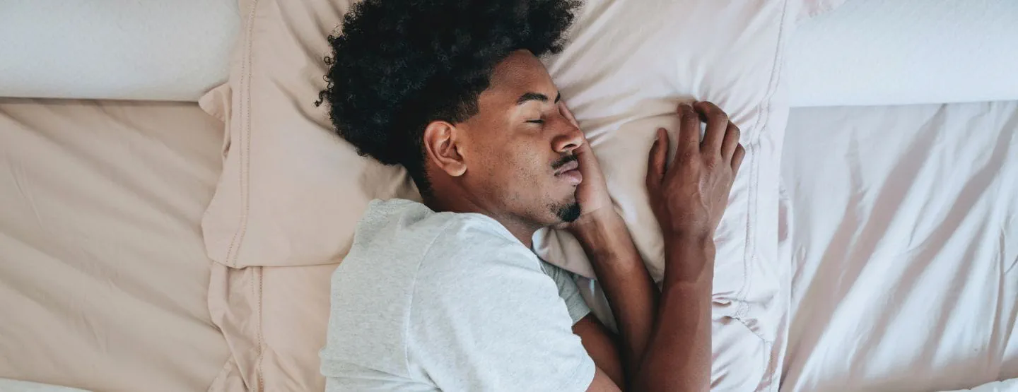 Young man sleeping in bed.