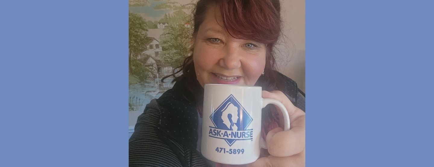Close up of Lauren Wuellner smiling at the camera, holding an Ask-a-Nurse mug.