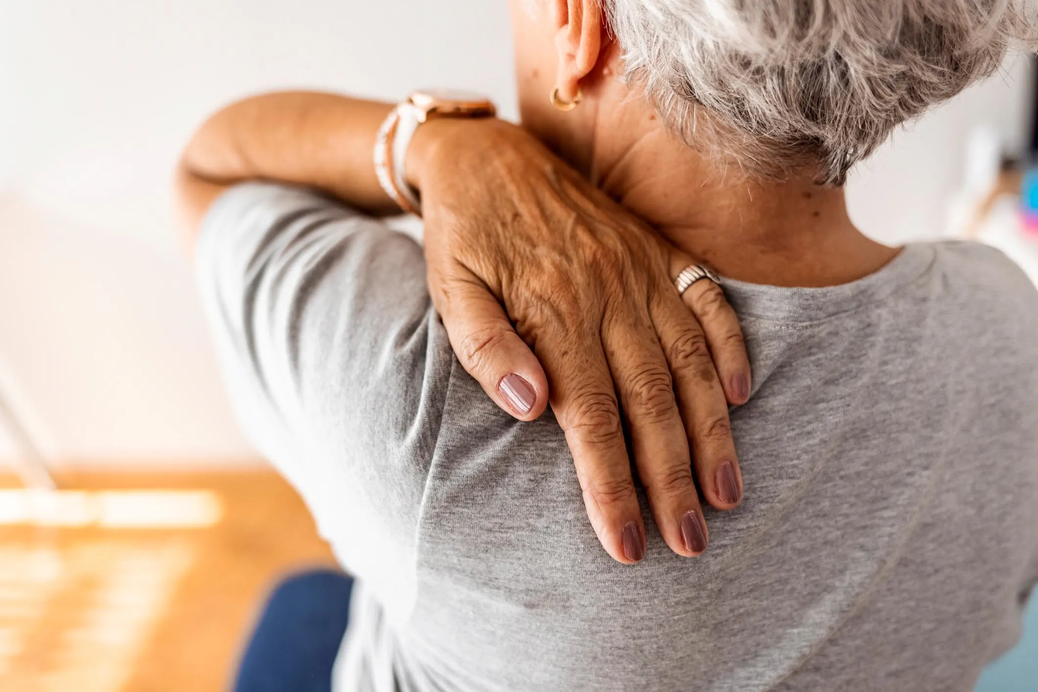 Shot of a senior woman experiencing neck pain at home