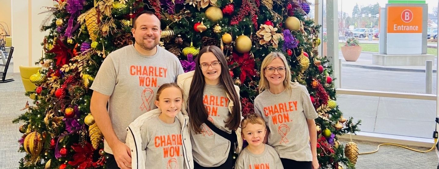 Myers family in front of a Christmas tree.