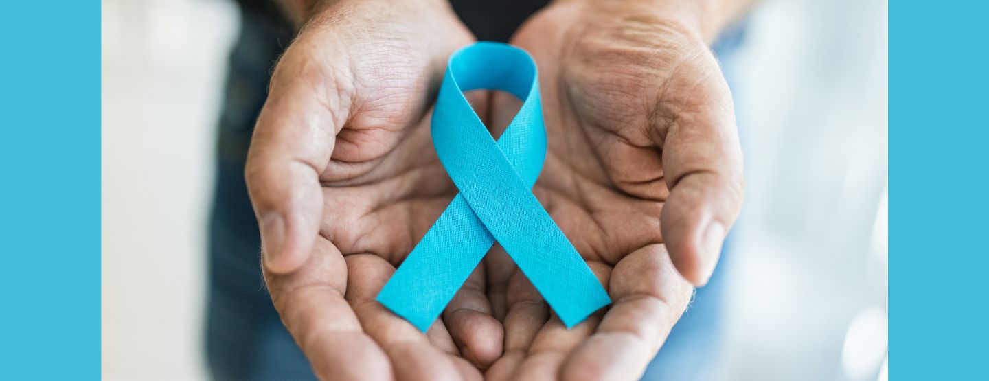 Older man's hands holding a blue ribbon.