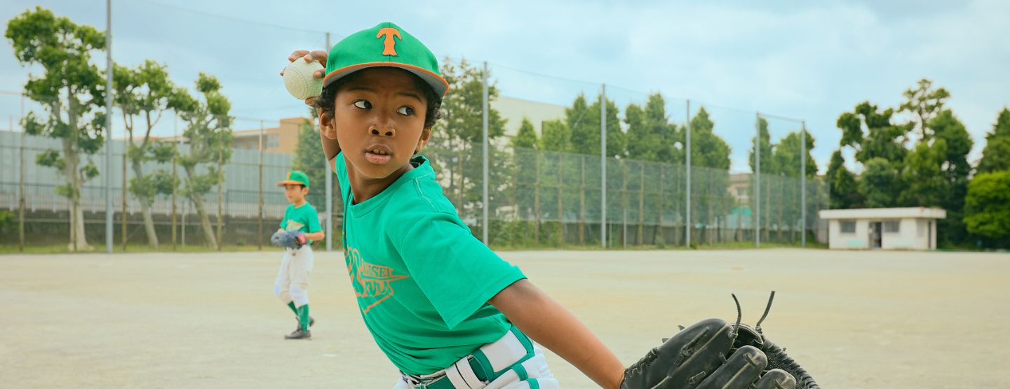 Young boy in baseball attire about to throw baseball. 
