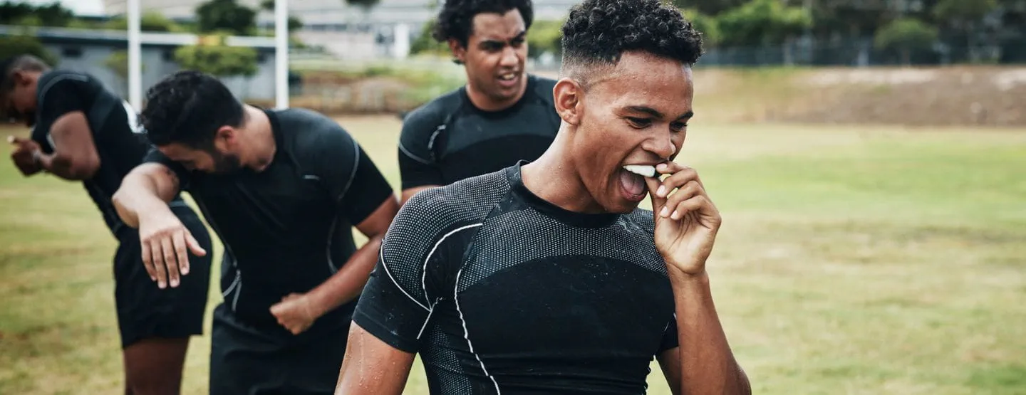 Athlete takes mouth guard out of mouth after game. 