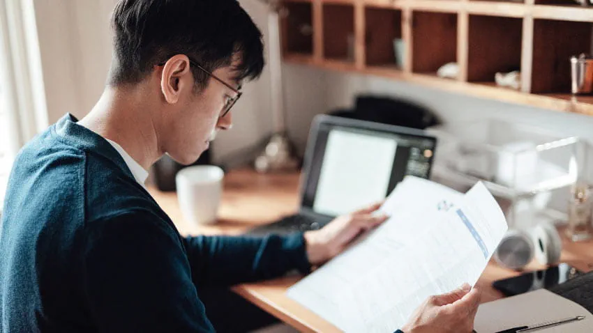 Man reviews medical bills at home.