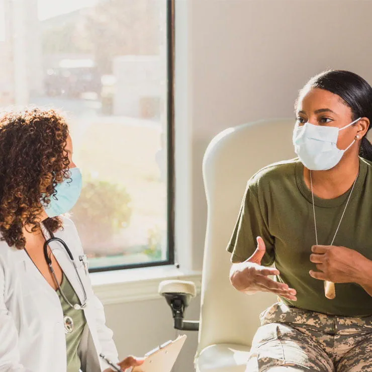 A female doctor discusses veteran benefits with a young female military member