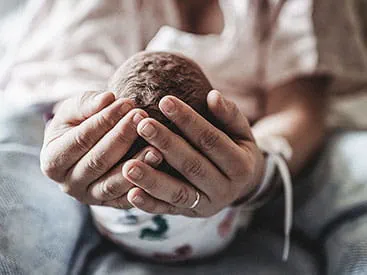 Hands holding infant