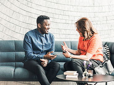 Young man and woman on sofa interacting