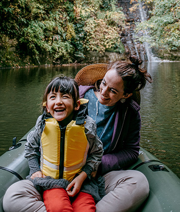 a woman and her young son enjoy kayaking on a river