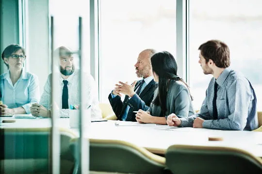 Mature male ProMedica executive leading a meeting in the hospital conference room 