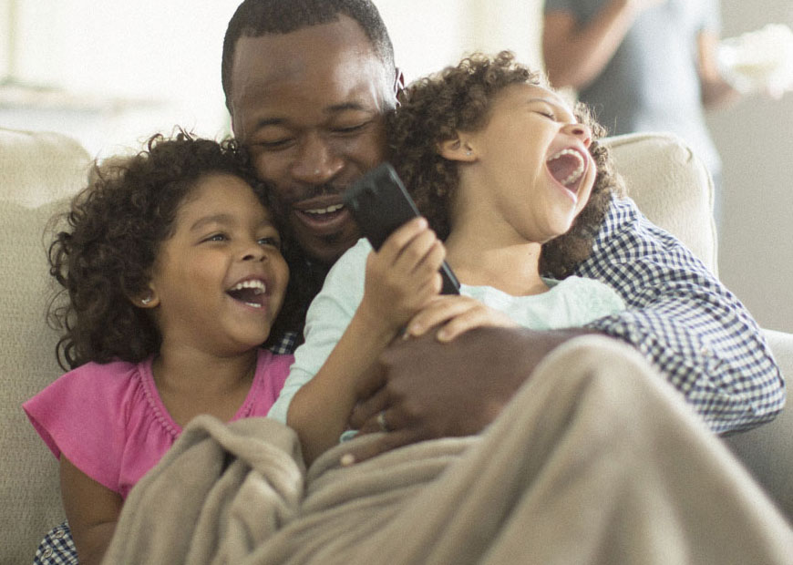 a grandfather hugs his two young granddaughters