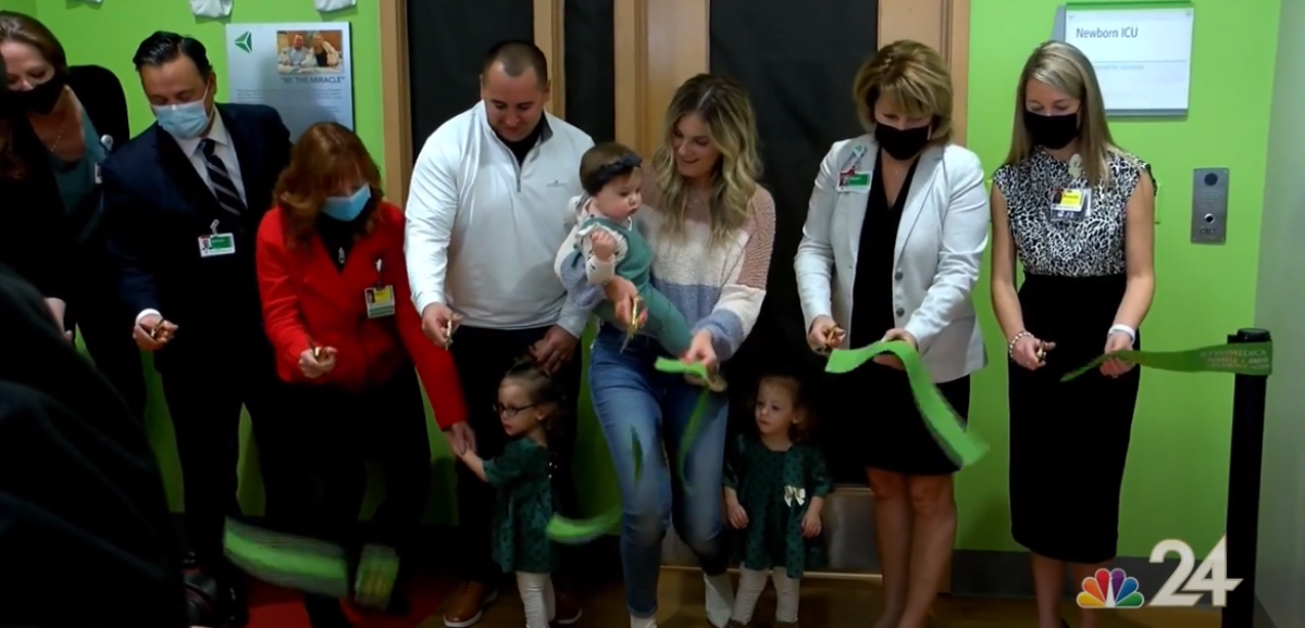 ProMedica representatives and a family of three cut a ribbon for the renaming of a NICU after the family who received care for preterm labor