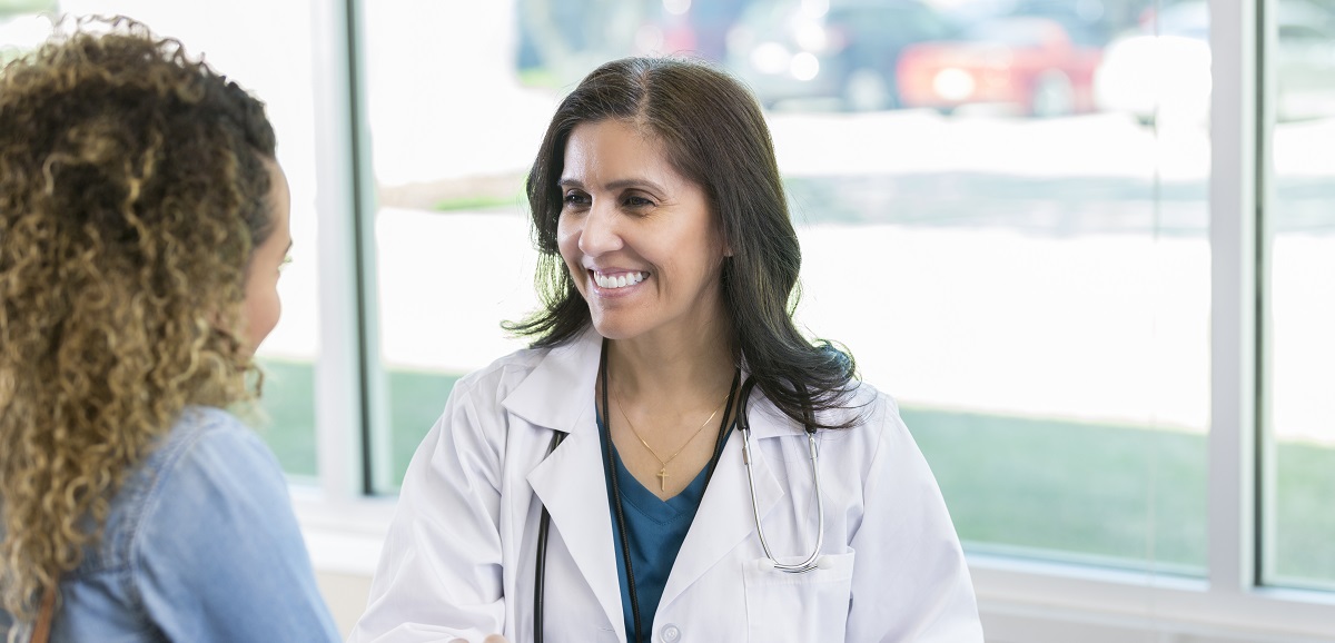 A female doctor talking to a female patient about screening options of cervical cancer.