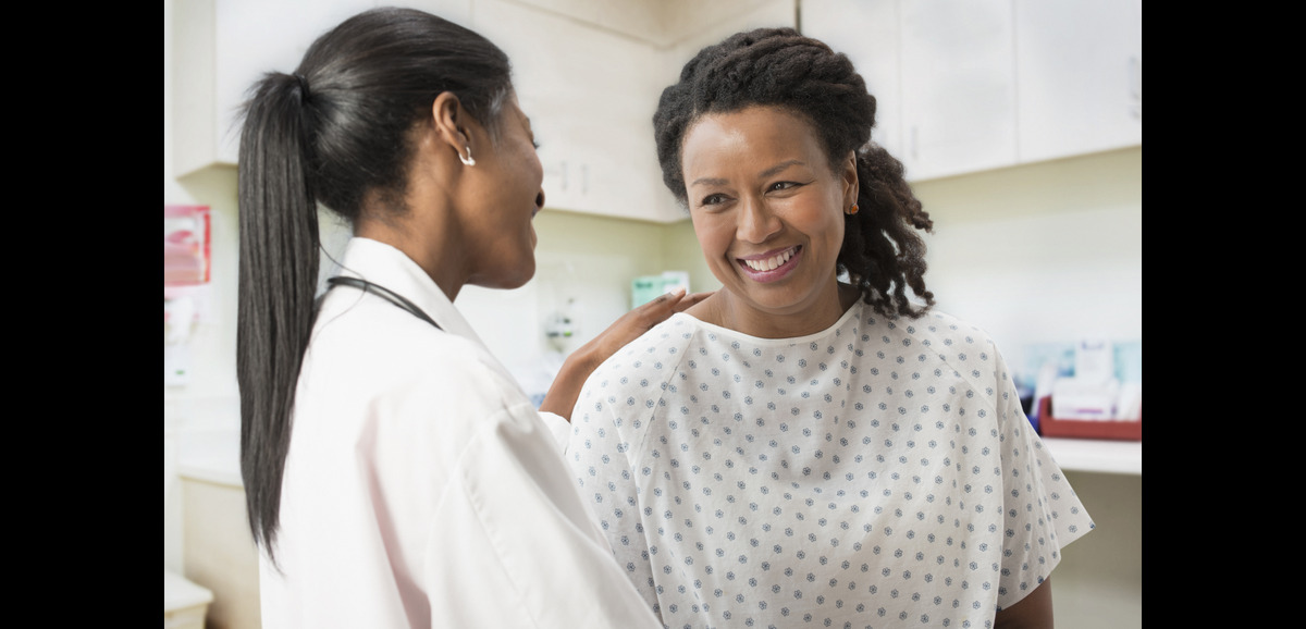 A female doctor reassuring her female patient during a consultation.