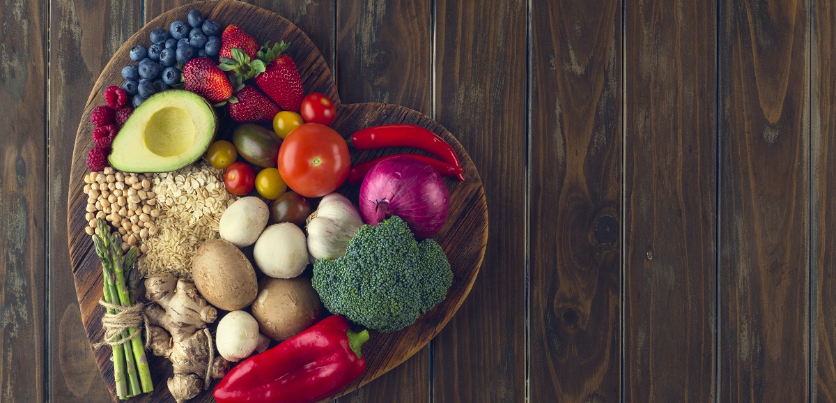 A picture of fruits and vegetables arranged in a heart shape. 