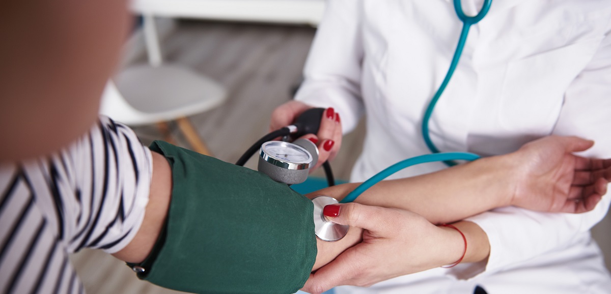 A patient getting their blood pressure checked by a nurse.