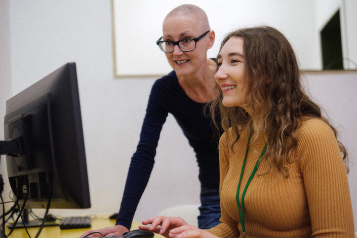 a patient navigator and a woman undergoing cancer treatment consult a computer screen