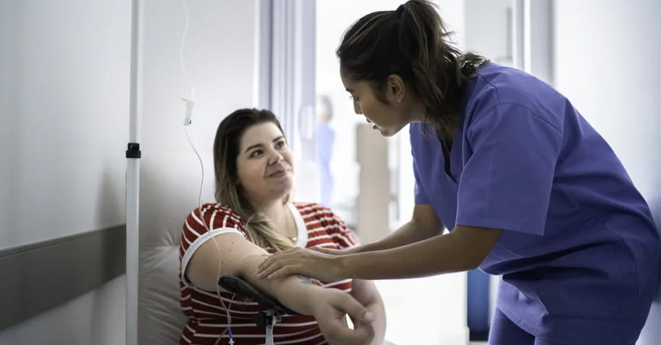 a nurse helps a patient prepare for an infusion therapy session