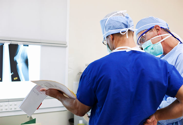 orthpaedic surgeons consult a patient chart 
