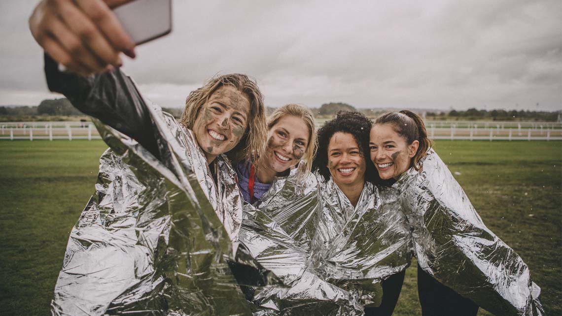 a group of women who have just completed a race take a selfie